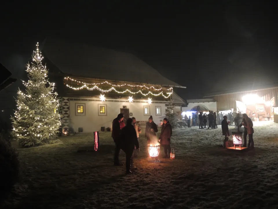 Christbaum und Feuer vor dem Eggerhaus bei Nacht