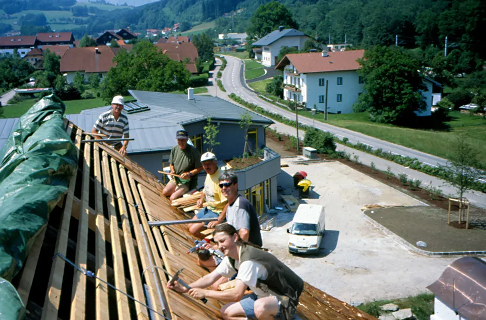 Helfer auf dem Dach beim Wiederaufbau